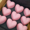 Pink heart-shaped objects in a box on a dark background