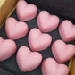 Pink heart-shaped objects in a box on a dark background